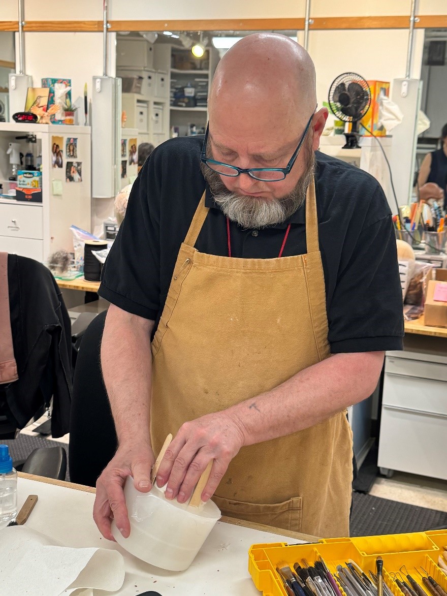 Wig and Make-Up Artist Tim Santry popping an ear casting out of its silicone mold