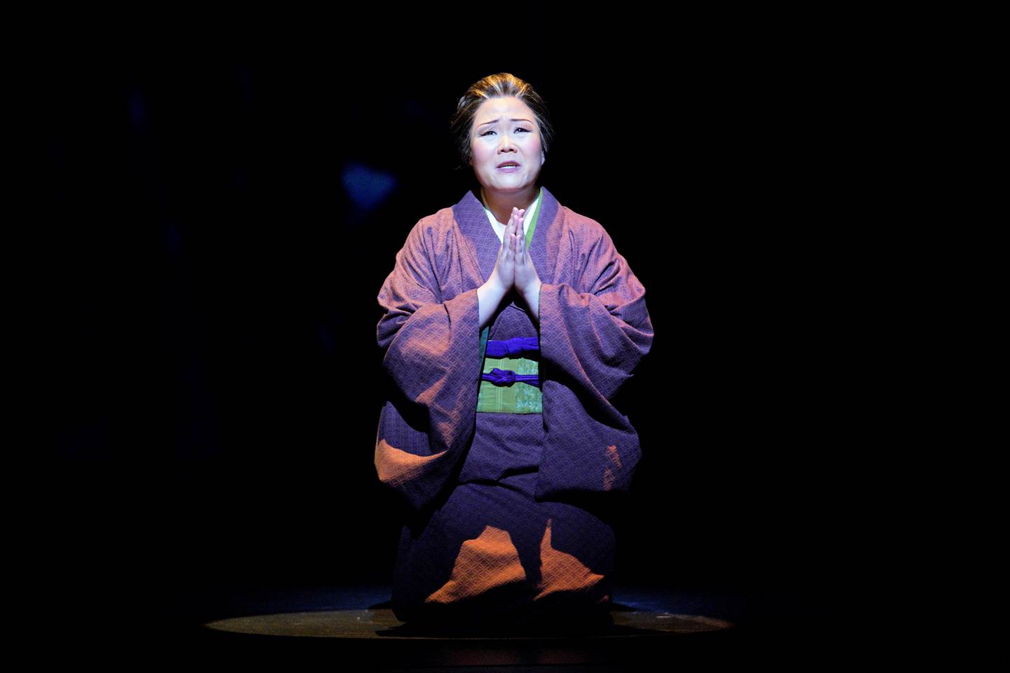 Madame Butterfly kneeling with praying hands