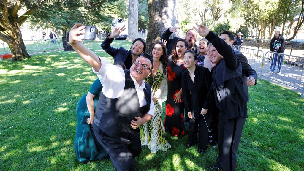 A group of young adults posing for a selfie on the lawn