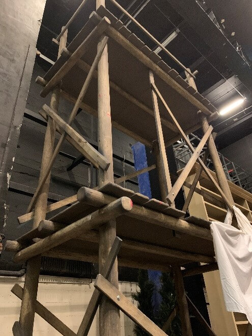 The stripped lumber used in the Figaro scaffold, both in its untreated state and then its finished state. You can then see the constructed scaffolding backstage during technical rehearsals.