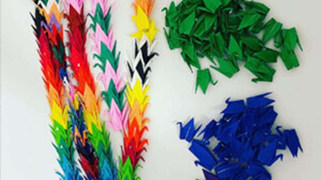 multi colored origami cranes stringed together.
