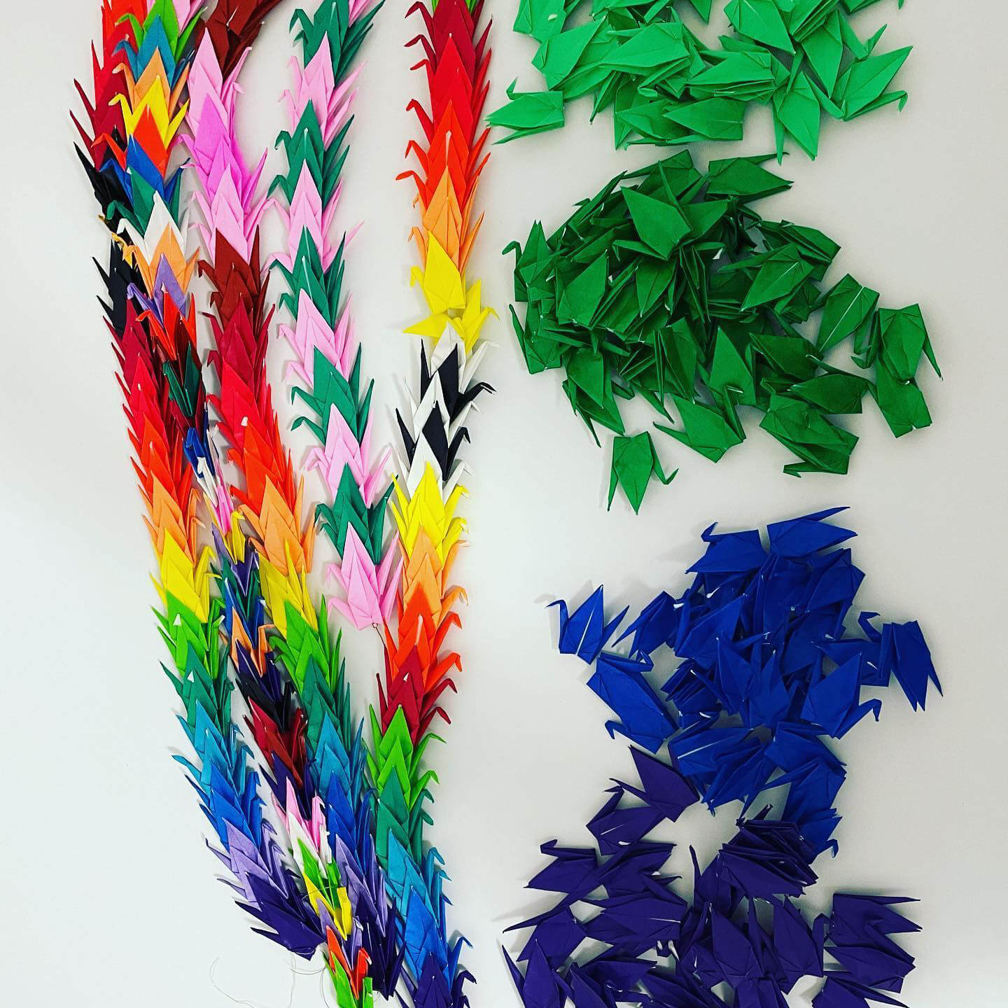 multi colored origami swan's stringed together.