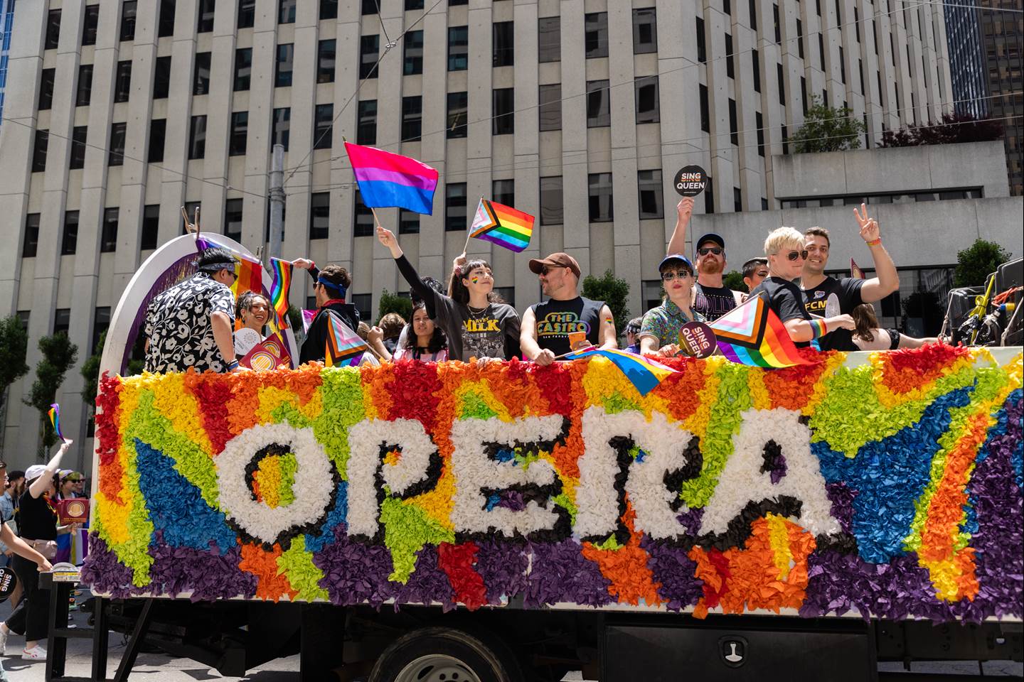 2023 Pride Parade San Francisco Opera float featuring people waving from a multicolored float with &#39;Opera&#39; spelled out in white letters